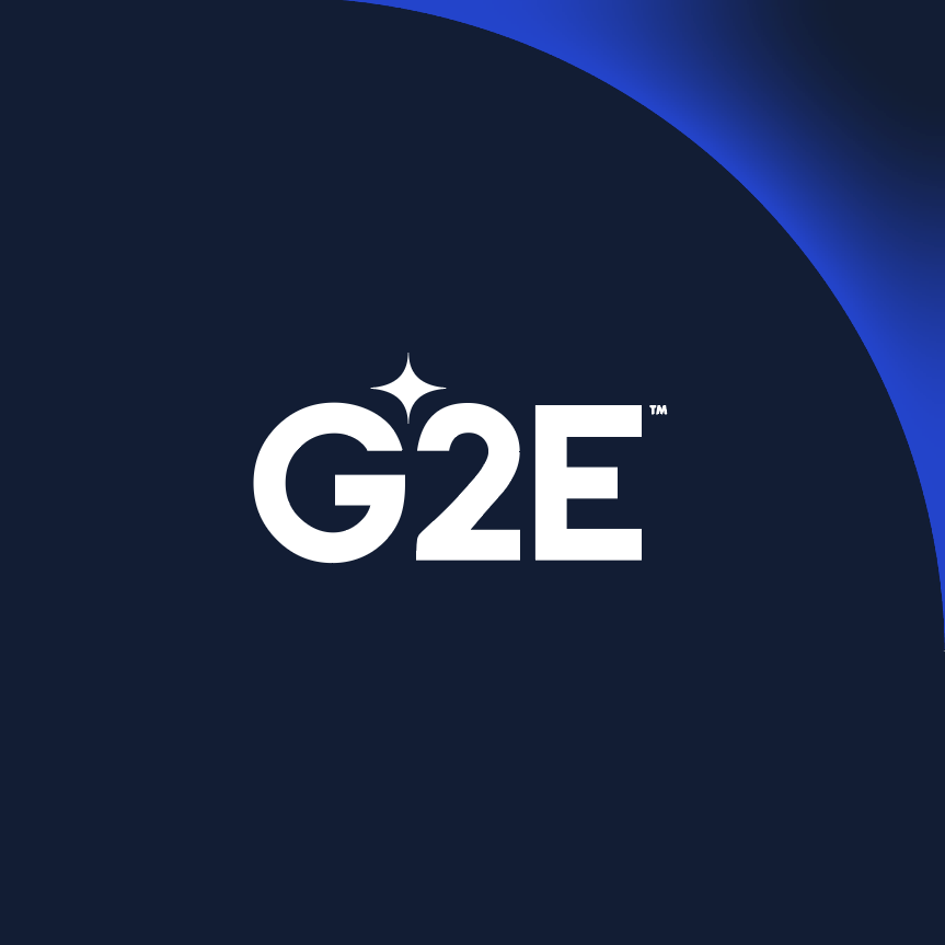 White "G2E" text with a sparkle icon above "2", set against a dark blue background. The upper right corner features a gradient blending from dark blue to a brighter blue, creating a modern and sleek design.