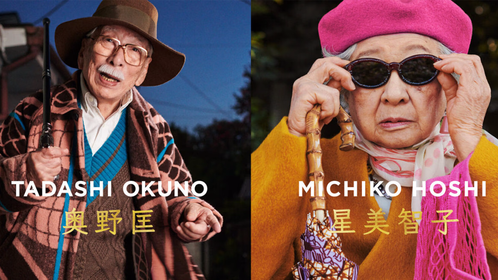 Two elderly individuals are featured side-by-side. On the left, a man, Tadashi Okuno, wears a hat and patterned shawl, holding a cane. On the right, a woman, Michiko Hoshi, wearing sunglasses and a colorful scarf, holds an umbrella. Their names are displayed in bold letters.