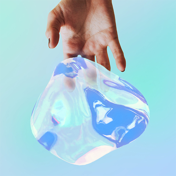 A hand with black nail polish on the thumb and index finger holds a transparent, iridescent blob against a light blue background. The blob reflects various shades of blue, green, and pink, creating a mesmerizing, otherworldly appearance.