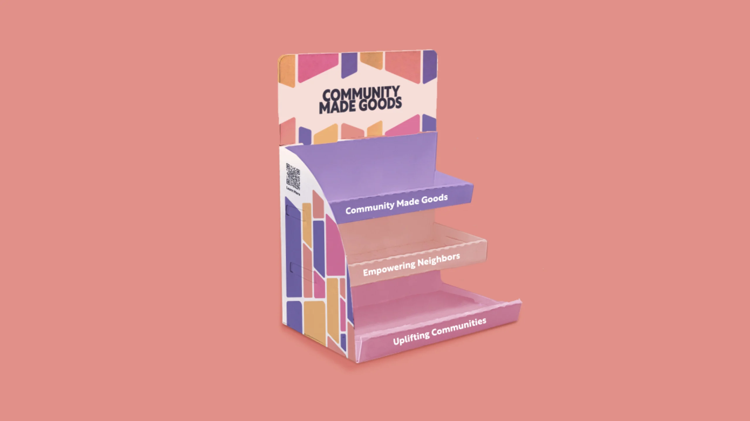 An empty, colorful product display stand labeled "Community Made Goods" with text "Empowering Neighbors" and "Uplifting Communities" on different shelves, set against a pink background. This vibrant showcase is dedicated to procuring impact by empowering communities and fostering social change.